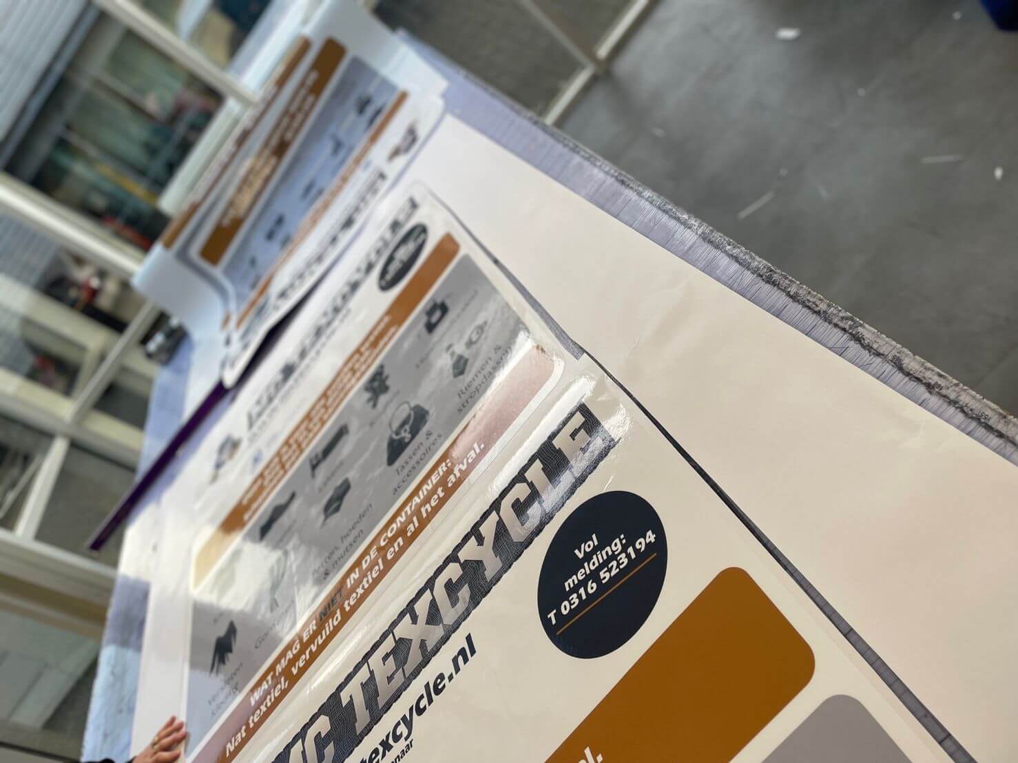 Nieuwe stickers op MC Texcycle inzamelcontainers